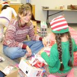 A picture of a student and volunteer going through gifts during Sugar Plum in 2022.